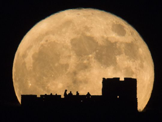 People watch the supermoon rise behind Coronado Heights near Lindsborg, Kan., on Nov. 14, 2018.