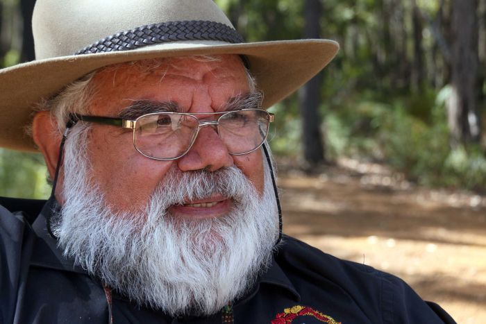 An indigenous man wearing a hat and glasses.