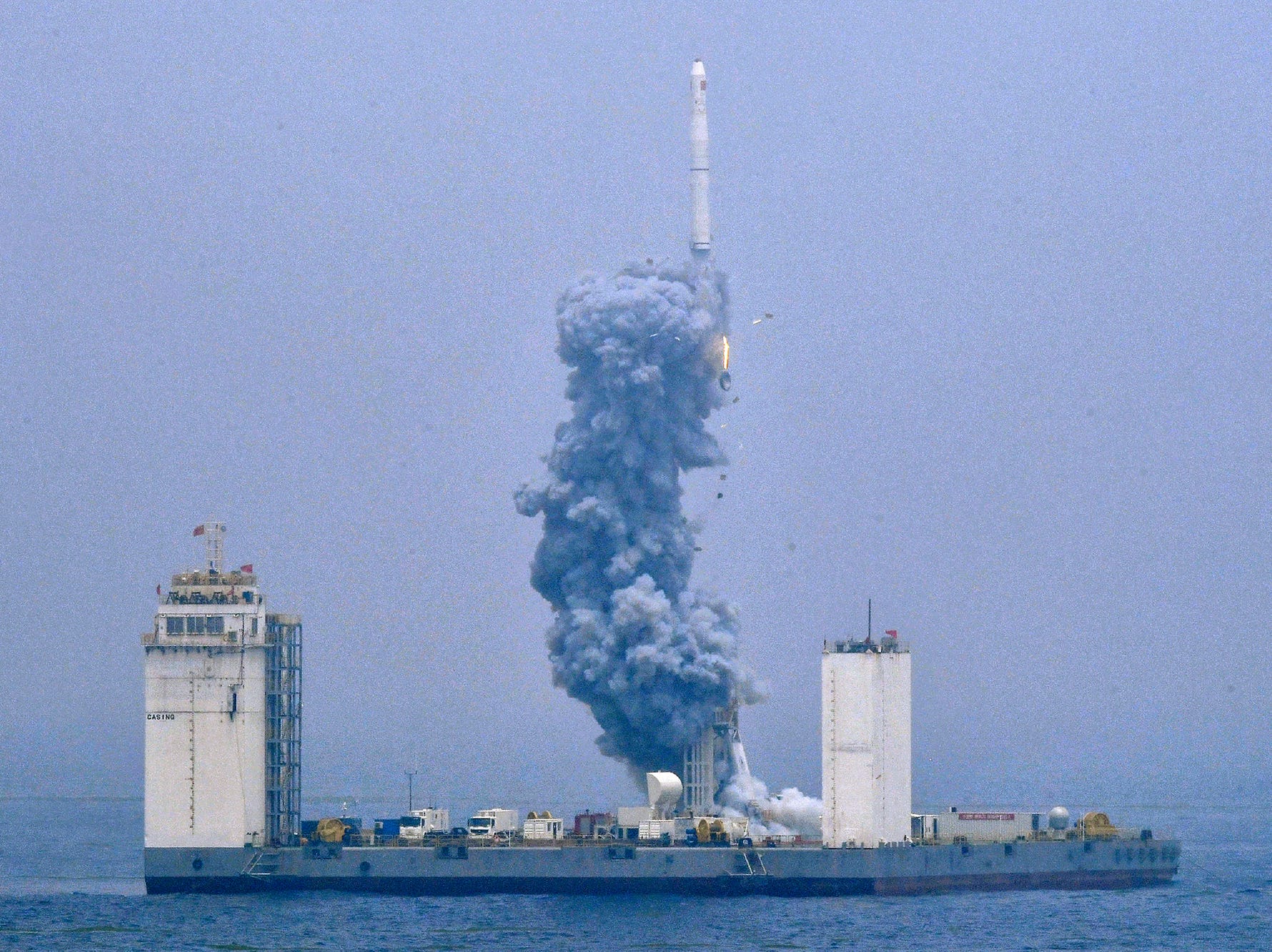 In this photo released by Xinhua News Agency, a Long March-11 solid propellant carrier rocket blasts off from a mobile launch platform in the Yellow Sea off east China's Shandong Province, Wednesday, June 5, 2019. China has for the first time launched a rocket from a mobile platform in the Yellow Sea, sending a five commercial satellites and two others containing experimental technology into space. (Zhu Zheng/Xinhua via AP) ORG XMIT: XIN801