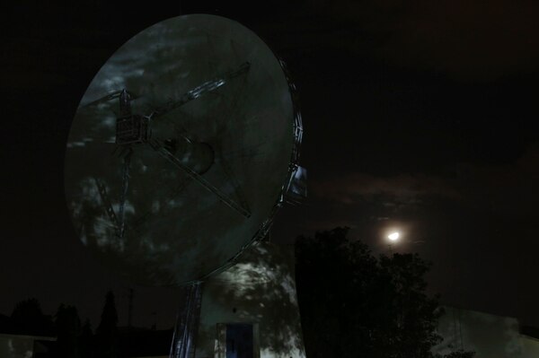 The moon is seen behind a tracking antenna at Indian Space Research Organization's Telemetry, Tracking and Command Network facility in Bangalore, India on Sept. 6. (Aijaz Rahi/AP)