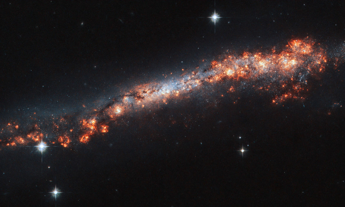 The edge-on spiral galaxy NGC 3432 shows off a lot of gas clouds in this image from Hubble Space Telescope. Credit: ESA/Hubble & NASA, A. Filippenko, R. Jansen