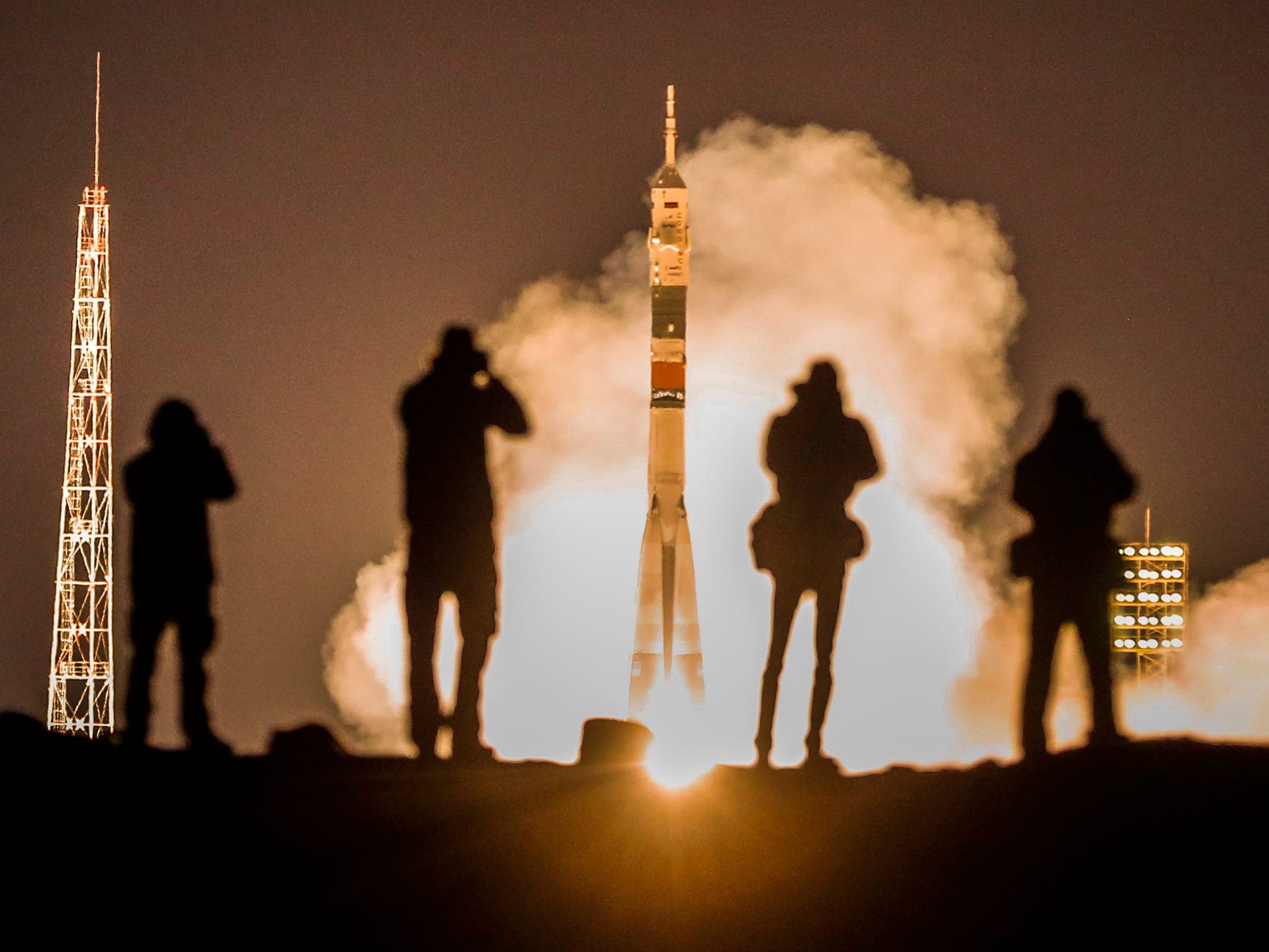 Photographers take pictures as the Soyuz MS-12 spacecraft with crew members of Expedition 59/60 Russian cosmonaut Alexey Ovchinin, NASA astronauts Christina Koch and Nick Hague lifts off from the launch pad at the Russian leased Baikonur cosmodrome, Kazakhstan on March 15, 2019. 