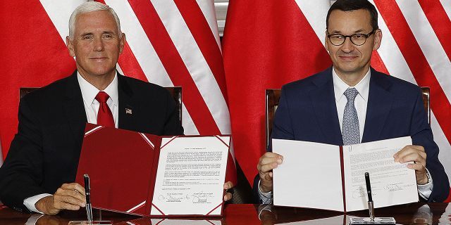 U.S. Vice President Mike Pence and Polish Prime Minister Mateusz Morawiecki, right, exchange copies of an agreement they signed in Warsaw, Poland, Monday, Sept. 2, 2019. (AP Photo/Czarek Sokolowski)