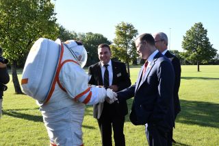 NASA Administrator Jim Bridenstine (right, foreground) shakes hands with a spacesuited subject during a tour of the University of North Dakota on Sept. 4, 2019. The NASA-funded UND spacesuit research is conducted under professor Pablo de Leon (center). At right, background, is North Dakota senator Kevin Cramer.