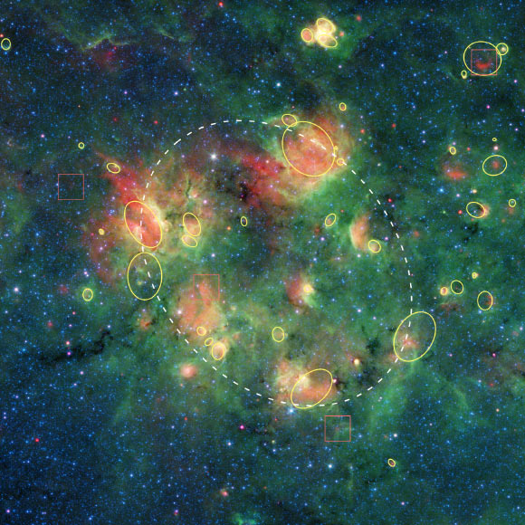 In this Spitzer image, the yellow circles and ovals outline more than 30 cosmic bubbles. Image credit: NASA / JPL-Caltech.