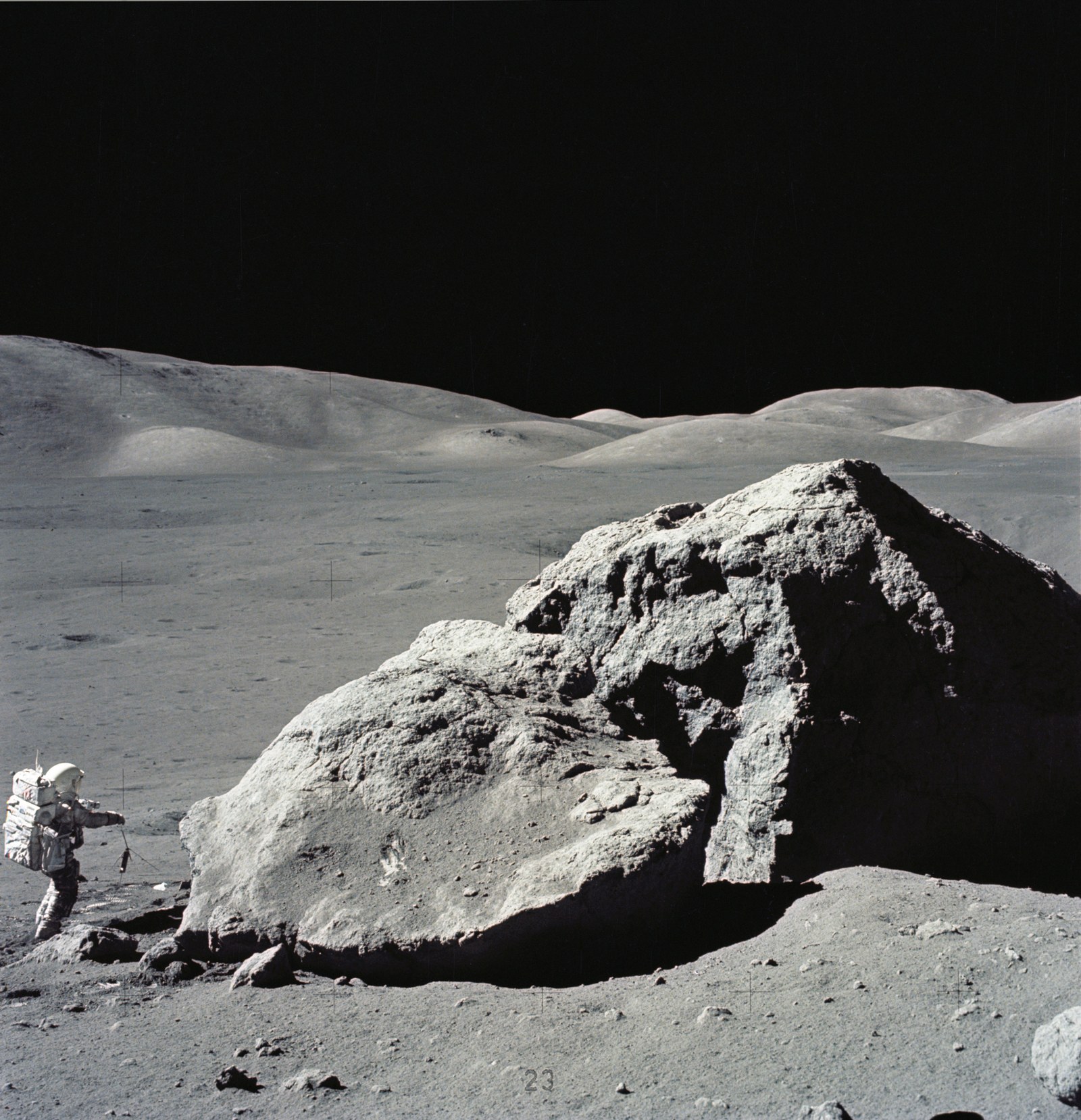 Astronaut Harrison H. Schmitt standing next to huge boulder