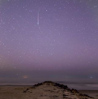 A bright Perseid meteor darts through a purple sky early Monday morning (Aug. 12) in this shot by astrophotographer Chris Bakley in Stone Harbor, New Jersey. In the distance about halfway down the photo, another fainter meteor can be seen dashing to the left.