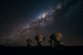 The Milky Way glistens above four antennas of the Atacama Large Millimeter/submillimeter Array (ALMA), a telescope array in northern Chile. The antennas, which are located at ALMA's Array Operations Site near on Chajnantor plateau, are at an altitude of about 16,400 feet (5,000 meters), and it's the second-highest facility in the world. 