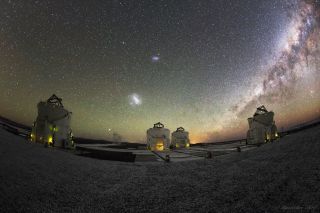 A view from the Very Large Telescope array in Chile shows four auxiliary telescopes under the Large and Small Magellanic clouds and the Milky Way.