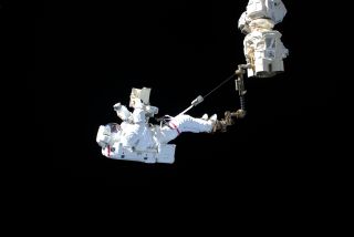 European Space Agency astronaut Luca Parmitano "stands" on the end of the International Space Station's Canadarm2 robotic arm during the first of four spacewalks to repair the Alpha Magnetic Spectrometer experiment together with NASA astronaut Drew Morgan, on Nov. 15, 2019.