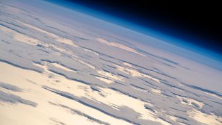 A sheet of clouds blankets the sky over the Pacific Ocean as light from the setting sun reflects off the surface of the water in this view from the International Space Station. An Expedition 59 astronaut captured this photo on Tuesday (June 11) when the space station was flying into the sunset about 650 miles (1,050 kilometers) off the coast of San Francisco.