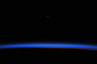 A tiny sliver of the crescent moons gleams above Earth's blue horizon just before sunrise in this stunning view from the International Space Station. NASA astronaut Christina Koch shared this image from space on Monday (Oct. 28), one day after the moon reached its new phase.