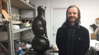 Matthew Serge Guy, who created a fundraising campaign to build a memorial for the first cat in space, poses with the completed statue of Félicette. 