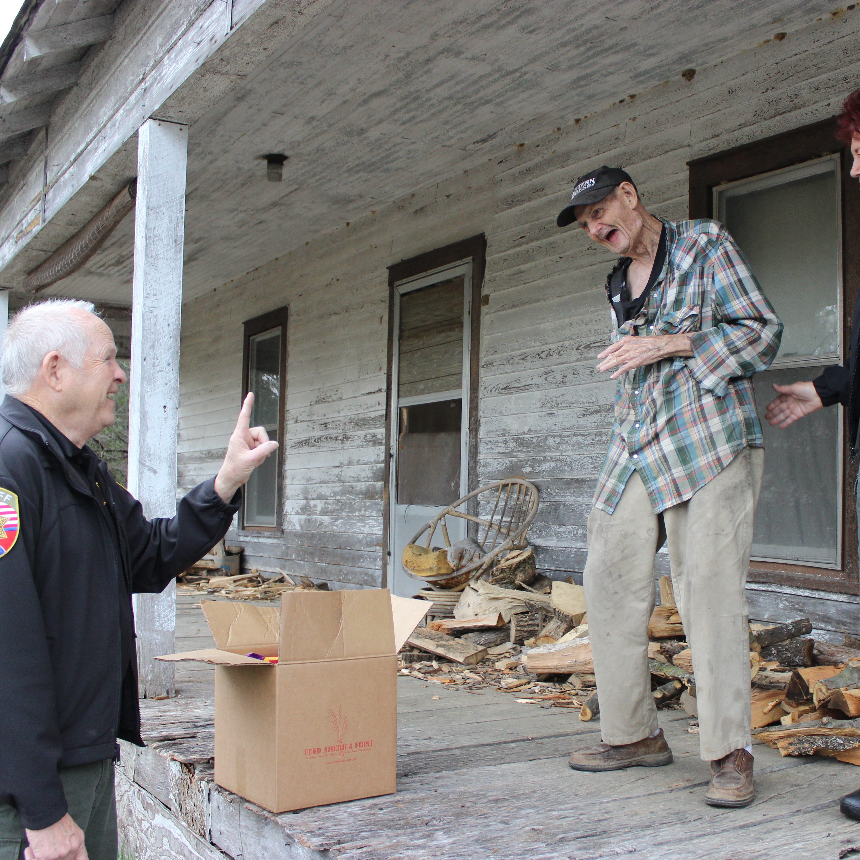 SCAN member James Rainey of Fosterville shares a laugh with SCAN coordinators Clarence Guice and E.T. Guice after they delivered a box of food to him Wednesday.