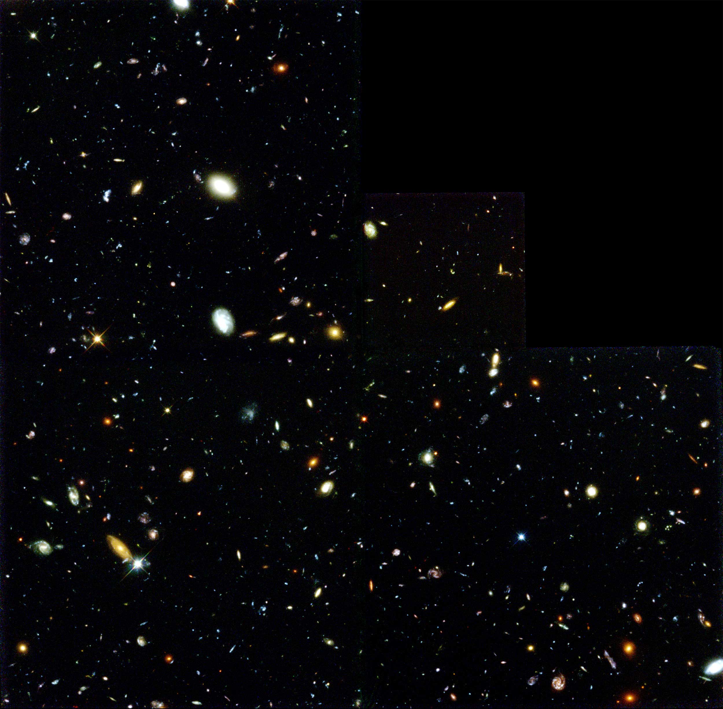 Thousands of galaxies of different shapes, sizes and colors dot a black rectangle.