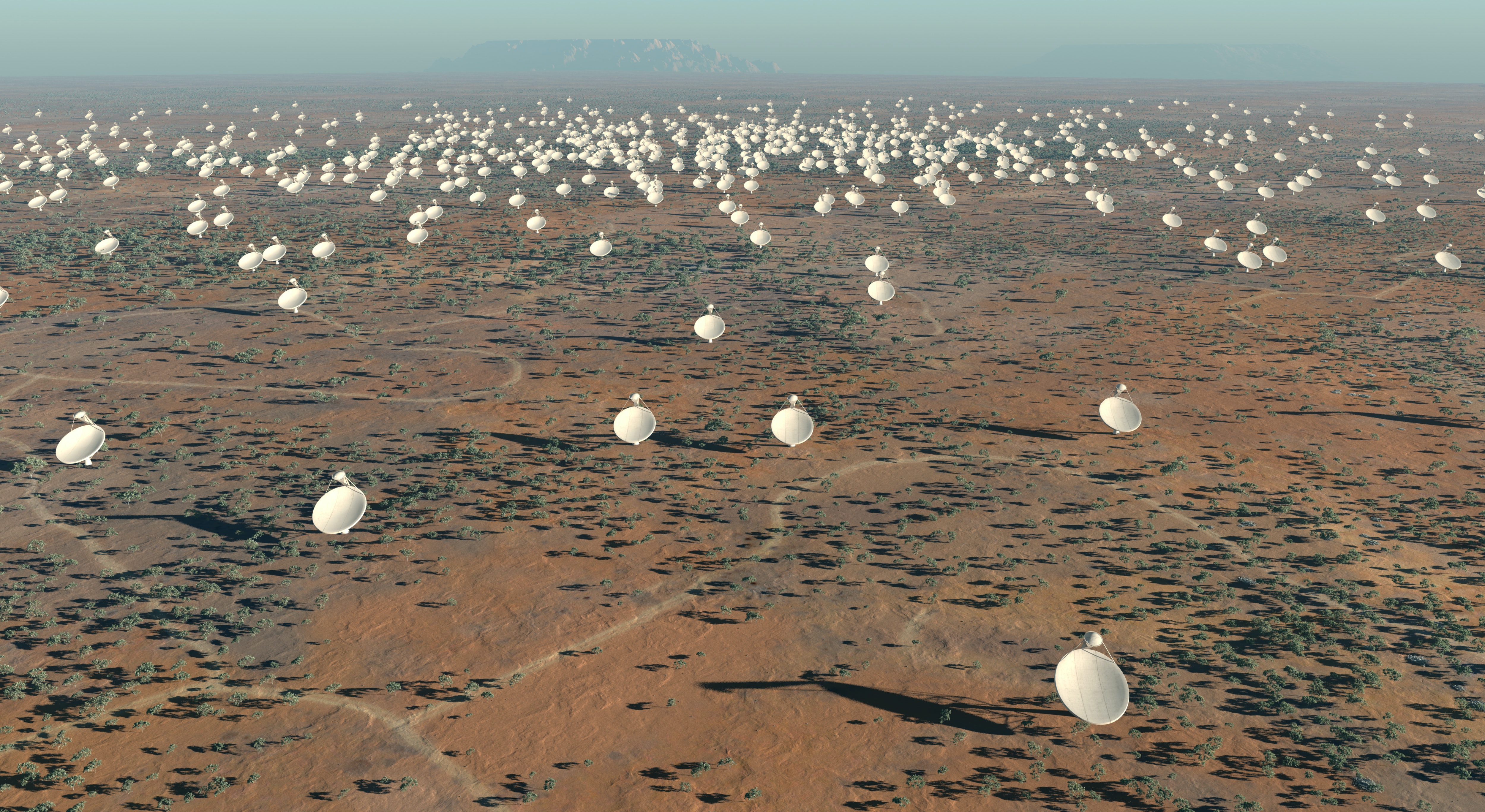 An aerial view of a desert with a huge number of satellite dishes.